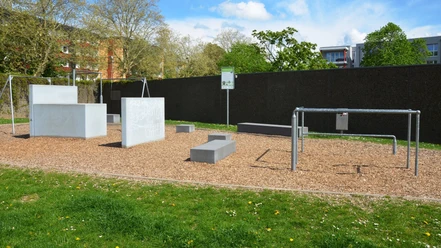Parcours_Salzgitter (4)_HD_16zu9.JPG Fitness-Parcours mit Betonblöcken und Metallstangen auf Rindenmulch in Salzgitter.