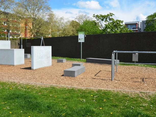 Parcours_Salzgitter (4)_HD_16zu9.JPG Fitness-Parcours mit Betonblöcken und Metallstangen auf Rindenmulch in Salzgitter.