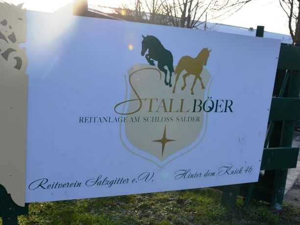 Reitstall_Böer_Salder_HD_16zu9.JPG Schild der Reitanlage Stall Böer und des Reitvereins Salzgitter an einem grünen Zaun.