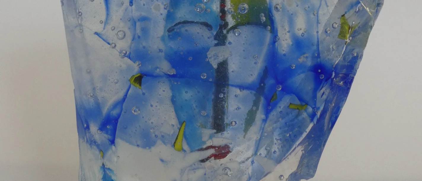 Glaskunst von Jacqueline Wehrmann in der Nische 9 in Stemwede, Gesicht versteckt in blauer Glasskulptur.jpg Skulptur aus Glas transparent mit Blautönen und einem im Glas versteckten Gesicht