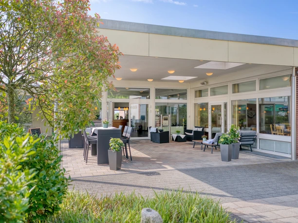 Terrasse der Wiehen-Therme mit Tischen, Stühlen und Glasfront des Restaurants