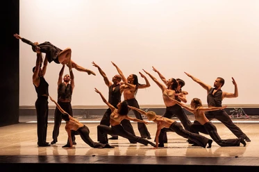 Dance Me – Music by Leonard Cohen Dance ensemble in synchronized pose, while a dancer is carried high above their heads.