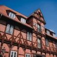 Lüner Mühle Historische Lüner Mühle: Fachwerkhaus aus rotem Backstein mit dunklen Balken vor blauem Himmel.