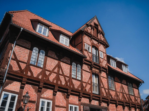 Lüner Mühle Historische Lüner Mühle: Fachwerkhaus aus rotem Backstein mit dunklen Balken vor blauem Himmel.