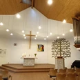 Friedenskirche_Salzgitter-Lebenstedt_HD_16zu9.jpg Heller Innenraum der Friedenskirche mit Altar, Kreuz, Orgel und Sitzreihen.