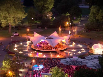 Tanzbrunnen Cologne Illuminated open-air stage in the park with water fountains and a packed audience.