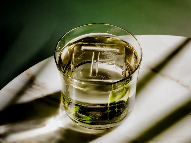 The Florentin - Drink Glass with drink and ice cube on marble table