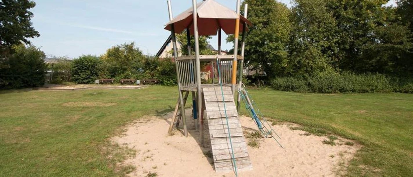 IMG_88181535622146_WEB.jpg Kletterturm auf dem Spielplatz Ostmarkstraße umgeben von einer Rasenfläche und Sitzbänken