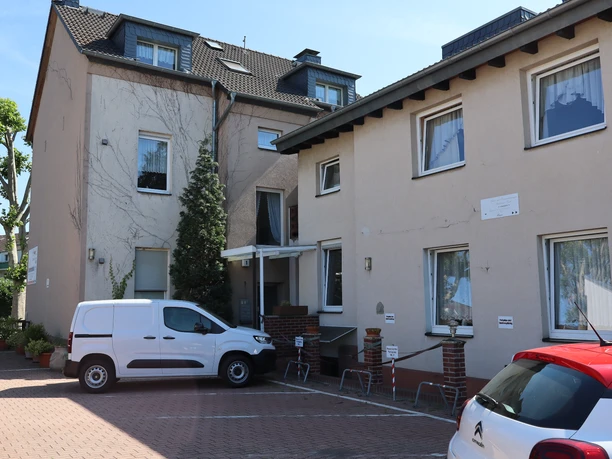 Gästewohnungen Koch in Ratingen Außenansicht der Gästewohnungen Koch in Ratingen mit zwei Gebäuden und Parkplatz.