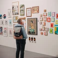 Urban Wildcard Art at Studio 40 Cologne Person looking at various works of art on a bright exhibition wall.