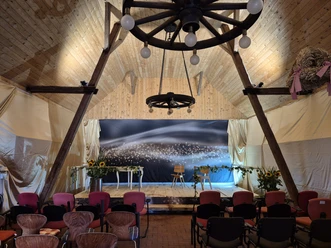 Kulturscheune Wehe, ein altes Wagenrad thront über der Bühne