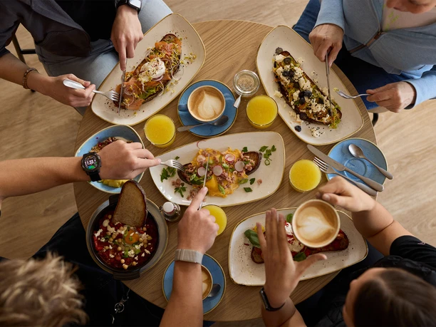 Café FRIDA in Büsum Vier Personen sitzen an einem Tisch und Essen.
