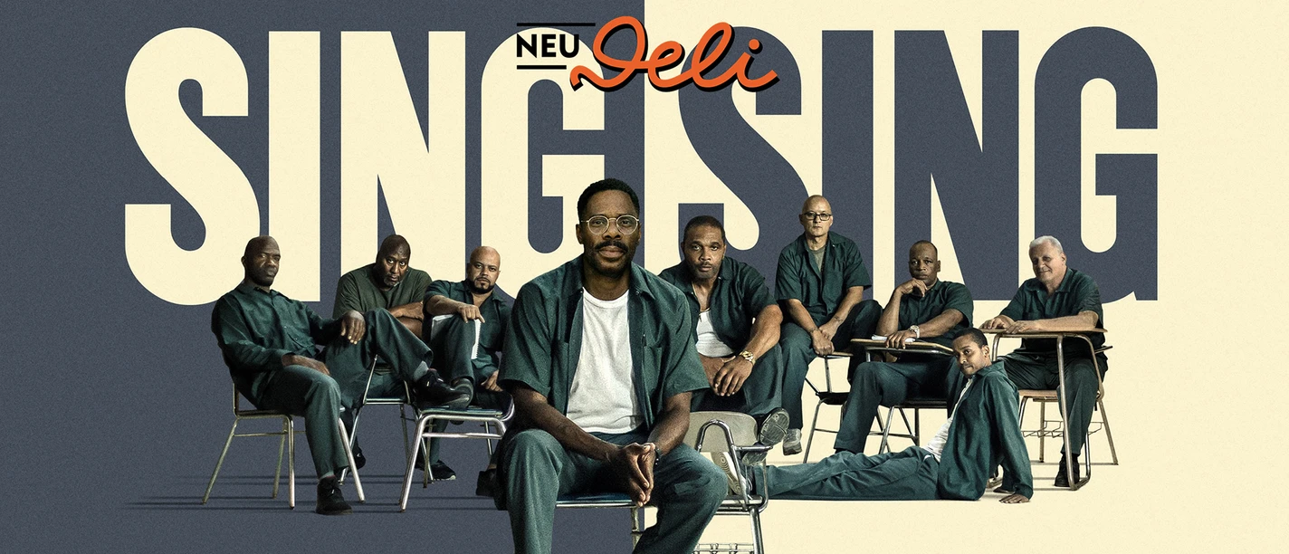 28-04 Sing Sing.jpg Filmposter Sing Sing: Männer in grüner Gefängniskleidung sitzen auf Stühlen.