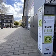 E-Bike-Ladestation am Marktplatz E-Bike-Ladesäule am gepflasterten Marktplatz mit umliegenden Häusern und Bäumen