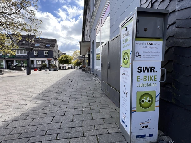 E-Bike-Ladestation am Marktplatz E-Bike-Ladesäule am gepflasterten Marktplatz mit umliegenden Häusern und Bäumen