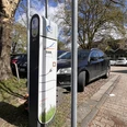 E-Tankstelle der Stadtwerke am Rathausplatz Ladesäule der Stadtwerke am Parkplatz vor Bäumen und abgestellten Autos.