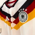 German national team jersey White soccer jersey with black, red and gold pattern and DFB emblem with four stars