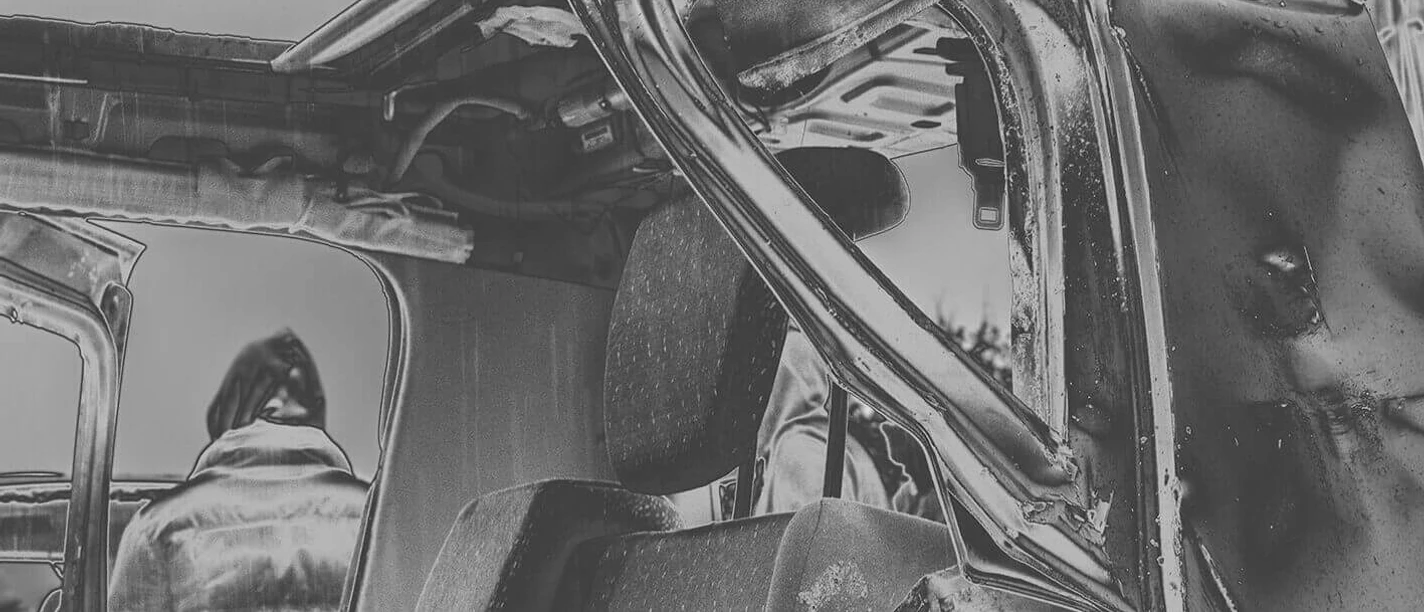 I Was the New World, raging for the machine Verbeulter Wrack mit zerknittertem Metall und einer Person im Hintergrund