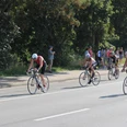 Triathlon_Salzgitter_HD_16zu9.JPG Triathleten auf Rennrädern fahren auf einer Straße an Zuschauern am Rand vorbei.