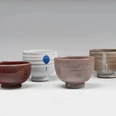 Young-Jae-Lee, Kummen, 2021 to 2024 Four differently glazed ceramic bowls next to each other on a light background