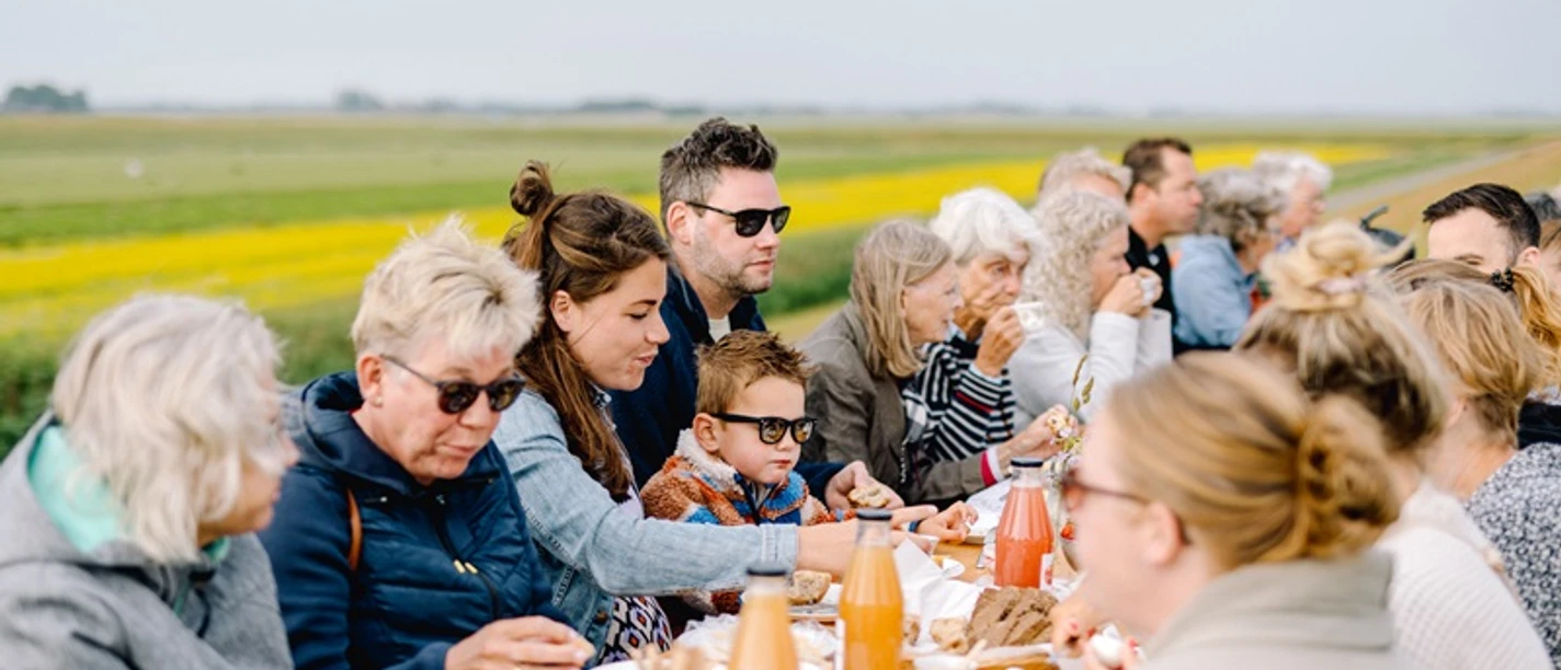 Frühstück am Deich in Friedrichskoog Personen unterschiedlichen Alters sitzen gemütlich zum Frühstück am Deich