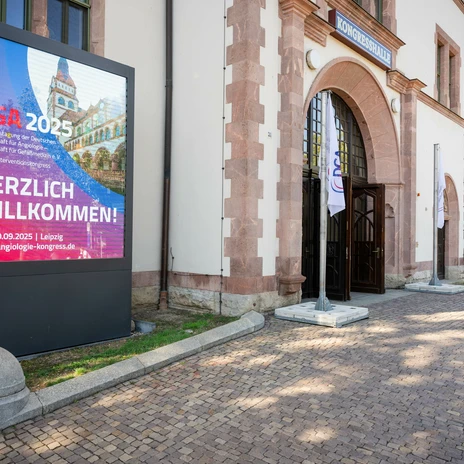 Eingang der KONGRESSHALLE am Zoo Leipzig zum 9. DGA Interventionskongress | Leipzig Convention Bureau Eingang der KONGRESSHALLE am Zoo Leipzig mit Stele und Willkommen zum 9. DGA Interventionskongress – präsentiert vom Leipzig Convention Bureau