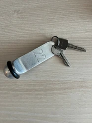 Zwei Schlüssel an einem massiven Metallanhänger mit der Nummer 22 auf hellem Holz.