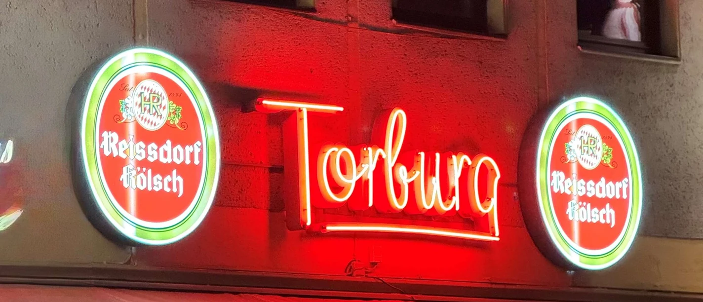 The Torburg in the Südstadt Night-time bar façade with red Torburg neon light and dense crowds in front of the entrance