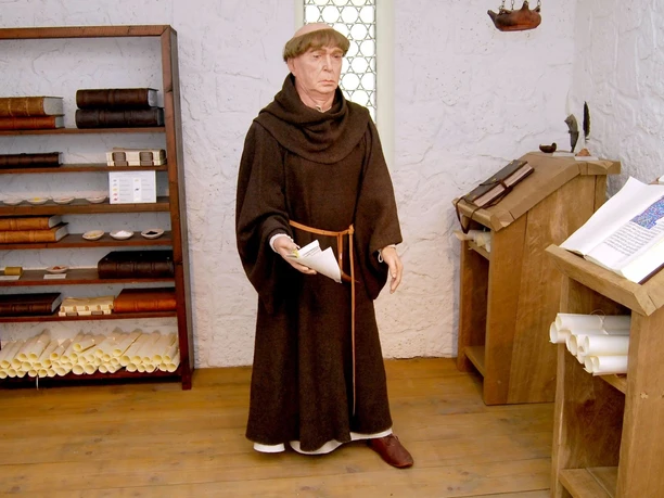 Ausstellung_Mittelalter_Kloster_Salder_HD_16zu9.jpg Figur eines Mönchs in Kutte in einer historischen Schreibstube mit Büchern und Pulten.