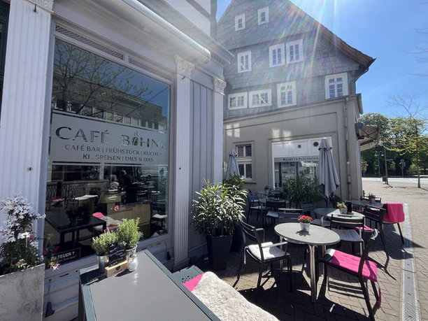 Café Bohne Außenterrasse des Café Bohne mit Tischen, Stühlen und Sonnenschirmen vor dem Gebäude