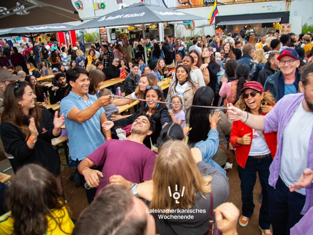 Lateinamerikanisches Wochenende an der Südbrücke Köln Große Menschenmenge feiert ein lateinamerikanisches Fest mit einer Limbo-Runde im Freien