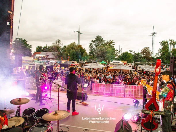 Lateinamerikanisches Wochenende an der Südbrücke Köln Bühne mit Band vor großer Menschenmenge auf farbig beleuchtetem Open-Air-Festival.