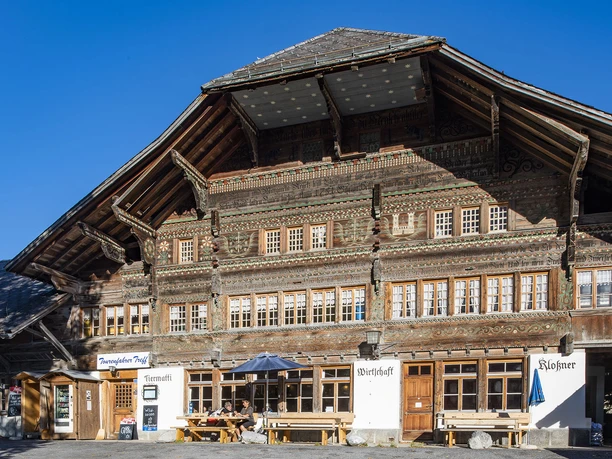 La maison Tiermatti Façade richement décorée d'une maison en bois avec un toit en croupe