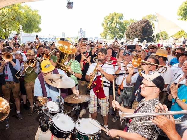 Original Egerländer Festival at Cologne's Tanzbrunnen Large crowd celebrates a brass band with trumpets and drums in the open air