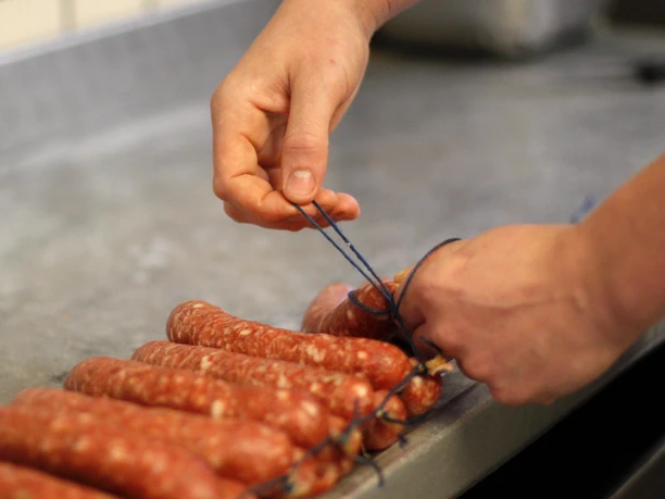 Eigene Wurstproduktion bei Fleischerei Thomas Kluke Abbildung der Handarbeit in der Fleischerei konkret bei der Wurstproduktion