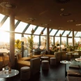 Sonnenuntergang in der Bar Botanik Helle Bar mit großen Fenstern, Pflanzen und modernen Sitzbereichen im warmen Abendlicht