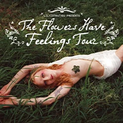 Person liegt in hohem Gras, darüber dekorativer Schriftzug zur The Flowers Have Feelings Tour.