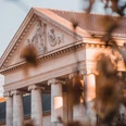 Neues Kurhaus (c) Niklas Birk.jpg Im Morgenlicht steht das Kurhaus Aachen vor unscharf gestellten Blättern eines Baumes.