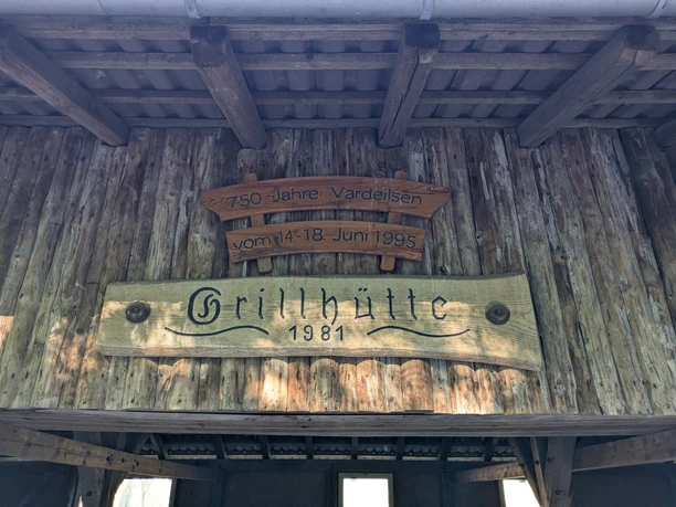Grillhütte, Vardeilsen, Panoramaweg Rustikale Holzwand mit zwei geschnitzten Schildern: 750 Jahre Vardeilsen und Grillhütte 1981.