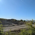 Steinbruch, Vardeilsen, Panoramaweg Felsiger Steinbruch Vardeilsen mit Erdwegen und Bagger unter blauem Himmel.