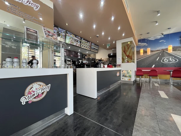 Mam's Burger Innenraum eines Burger-Imbisses mit Theke, Menütafeln und Sitzplätzen im Route-66-Stil.
