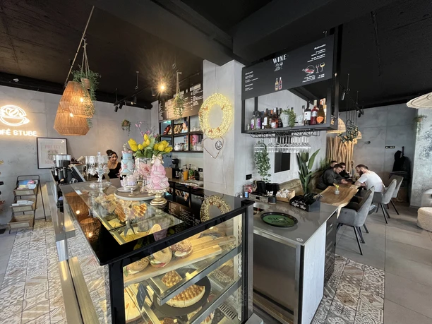 Café Stube Innenraum eines Cafés mit Theke, Kuchenvitrine und Sitzplätzen an Holztischen