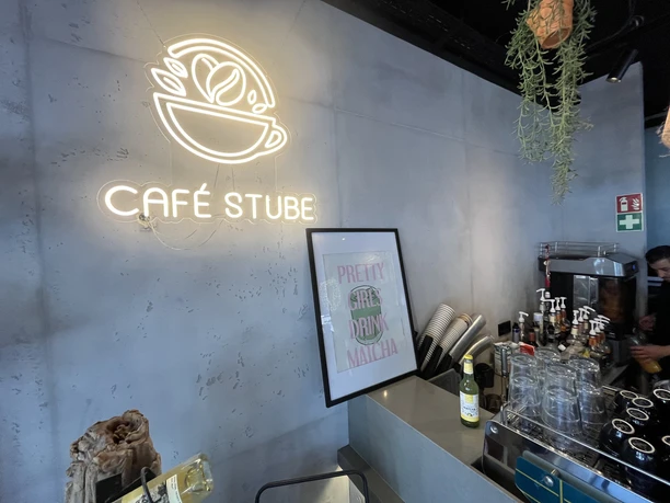 Café Stube Neonschild Café Stube über Theke mit Kaffeemaschine und Gläsern