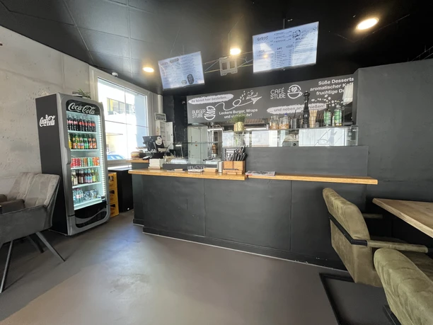 Burger Stube Innenraum eines Imbisses mit Theke, Menütafeln und Getränkekühlschrank im modernen Stil