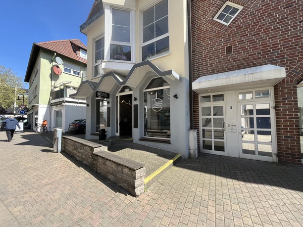 Burger Stube Eingang der Burger Stube mit grauer Fassade und markantem Vordach in Innenstadtlage