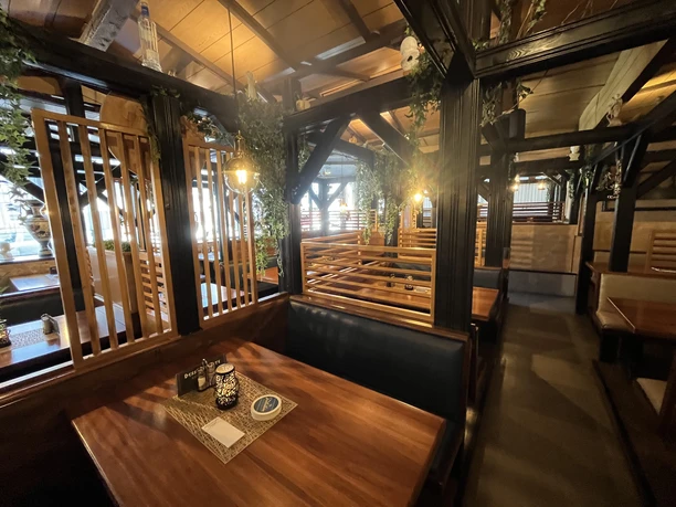 Syrtaki Innenraum mit Holzbänken, Trennwänden und warmem Licht im griechischen Restaurant