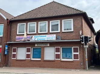 Atoll1 Liebenau Rotes Backsteinhaus an einer Straße mit Schild Apartment Zimmer atoll1 an der Fassade.