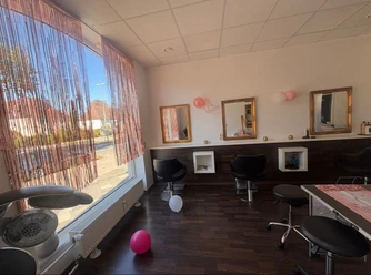 Kindergeburtstag im Salon Haarkunst Heller Friseursalon mit schwarzen Stühlen, goldenen Spiegeln und rosa Luftballons.