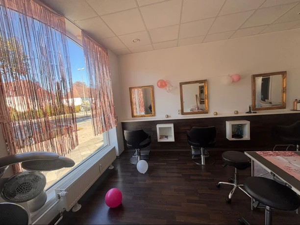 Kindergeburtstag im Salon Haarkunst Heller Friseursalon mit schwarzen Stühlen, goldenen Spiegeln und rosa Luftballons.