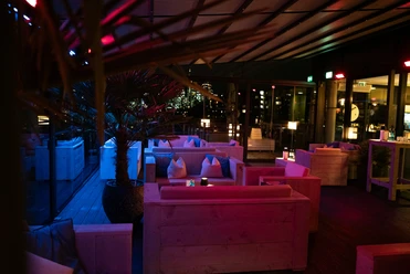 OOSTEN - Dachterrasse Rooftop‑Bar bei Nacht mit Blick auf Frankfurter Skyline